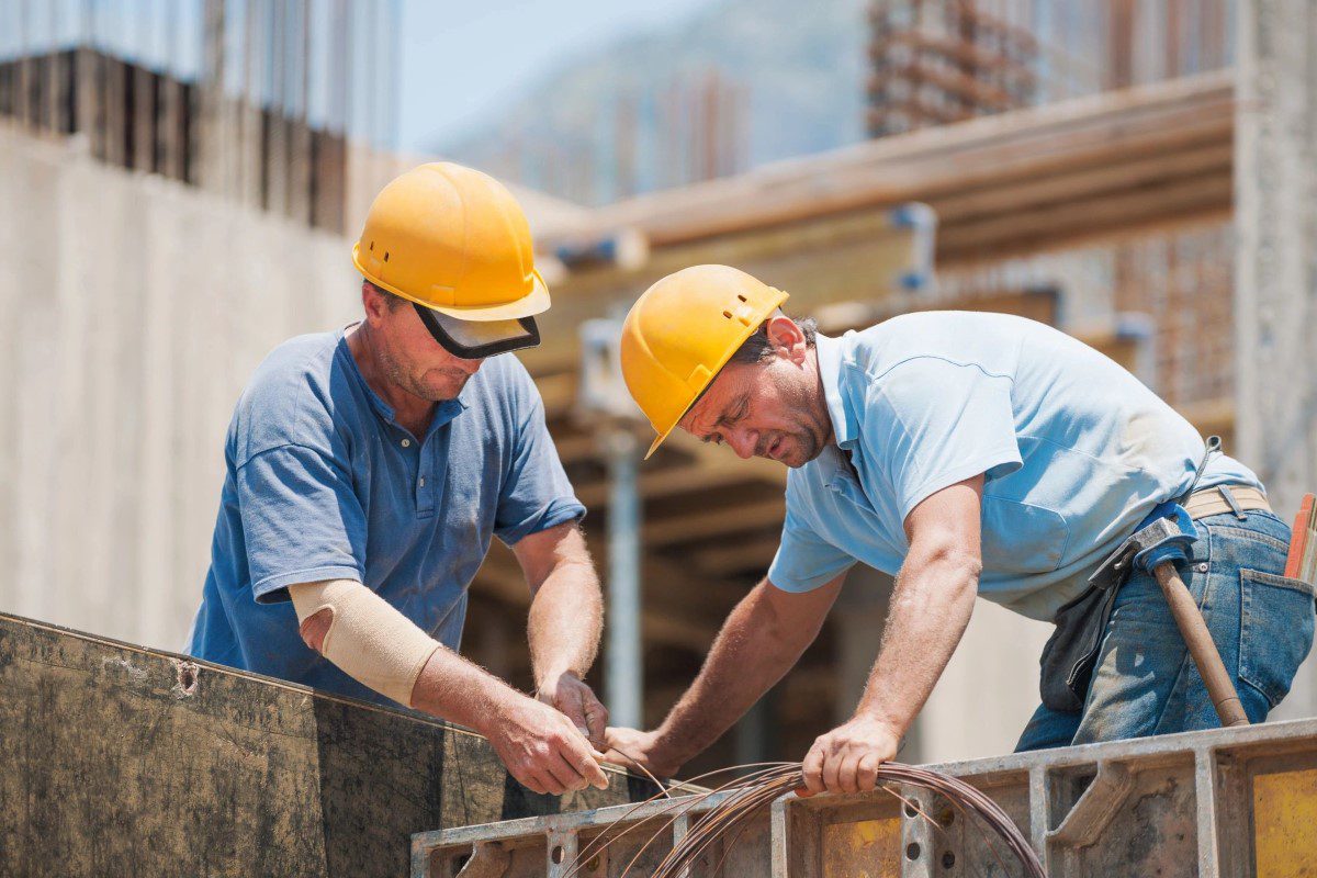Two men in hard hats working on a construction site.