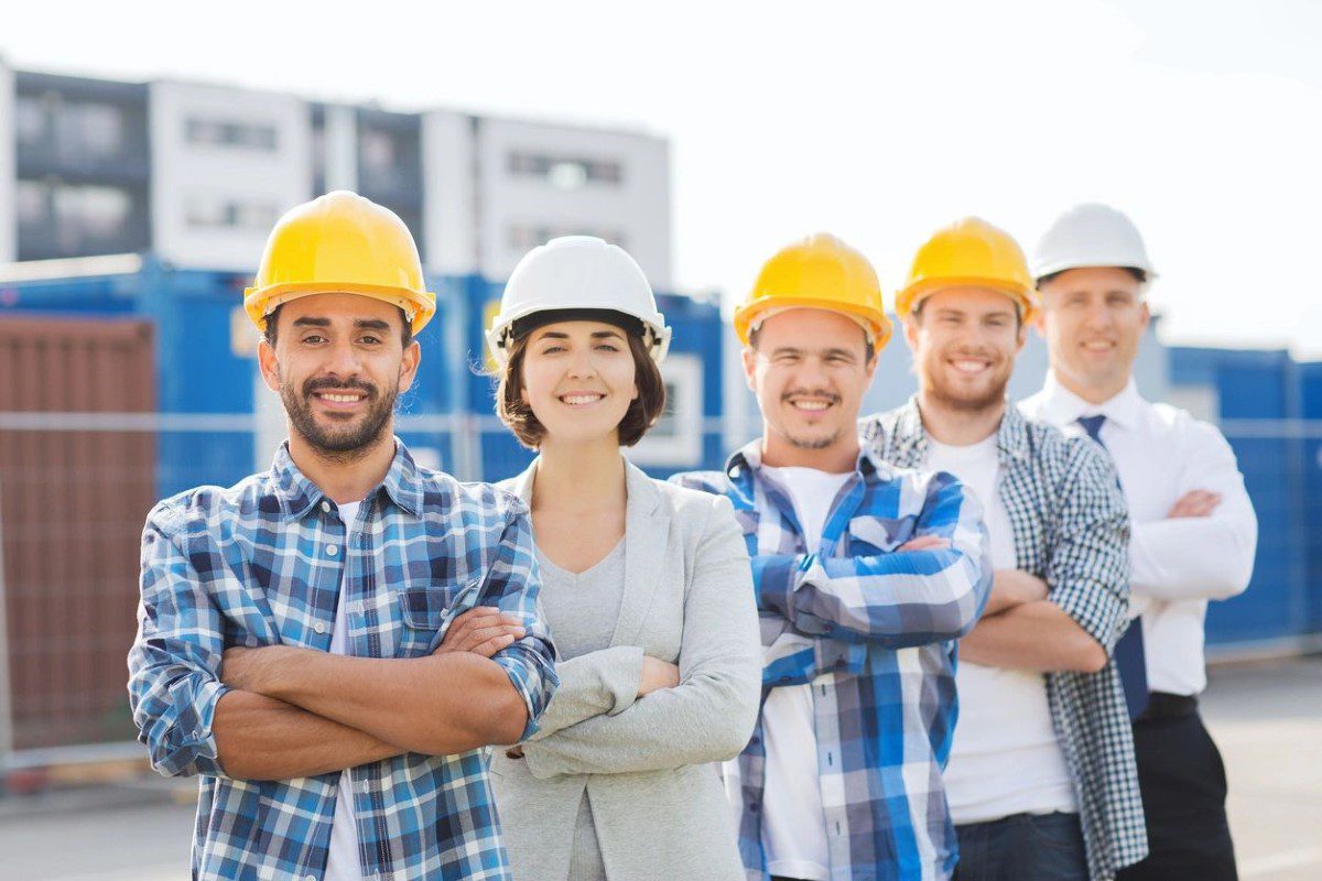 A group of people wearing hard hats and smiling.