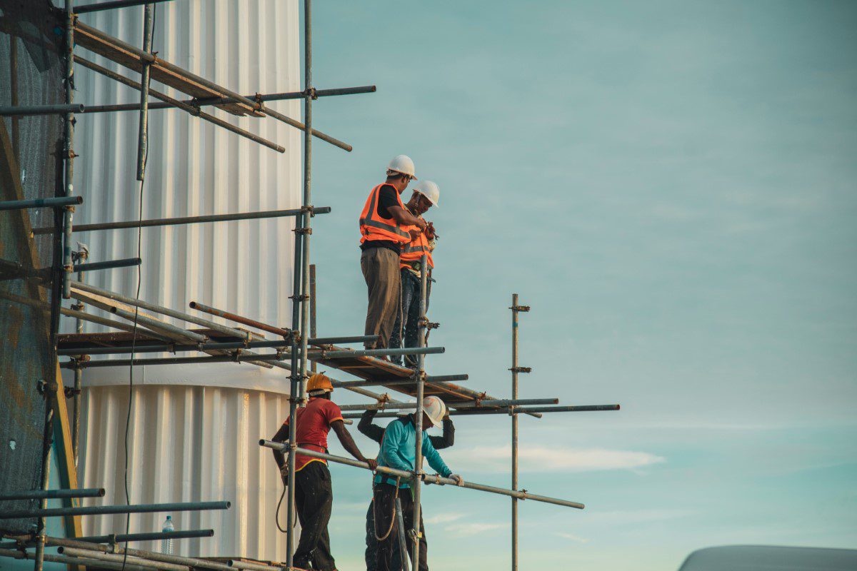 A group of people standing on top of scaffolding.