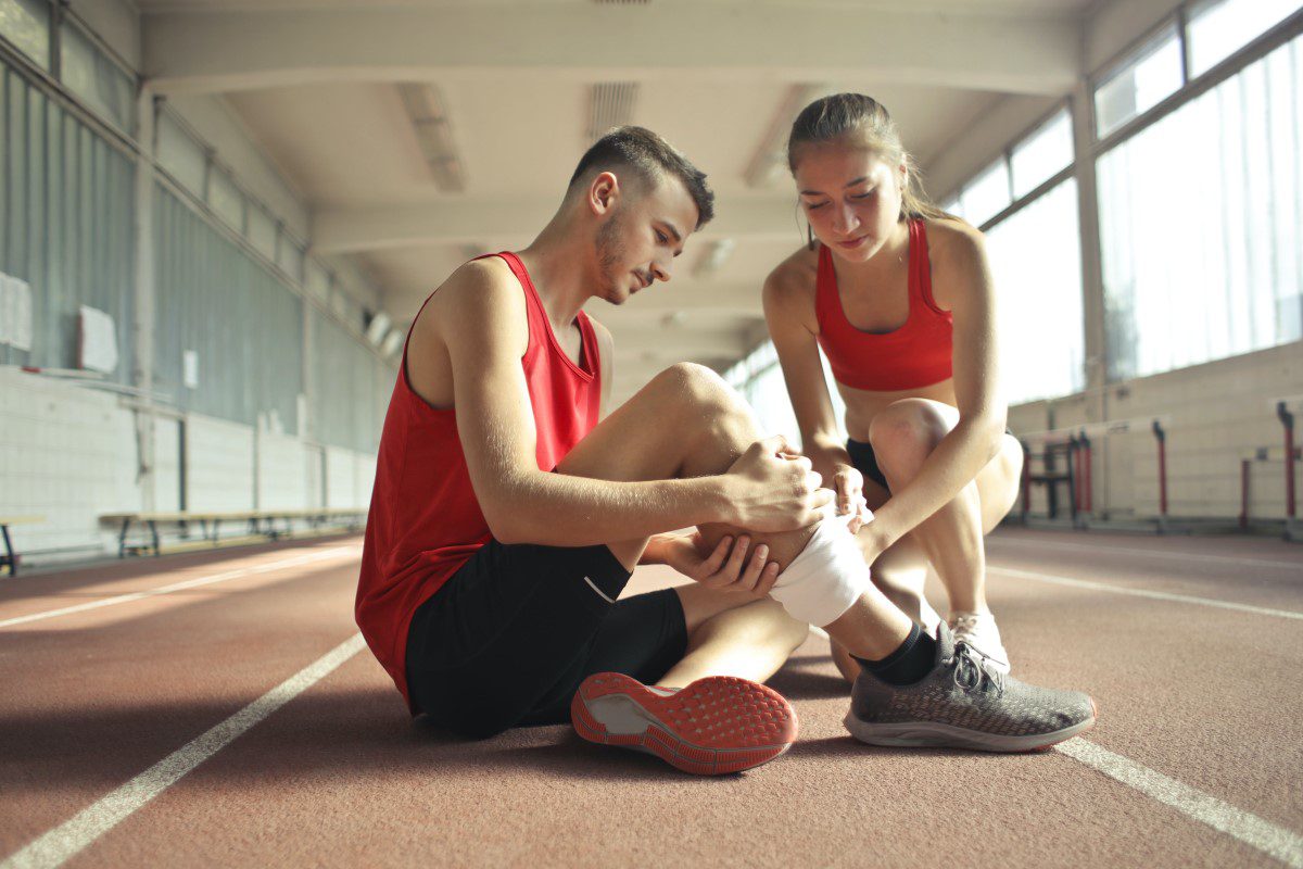 A man and a woman are sitting on a running track.